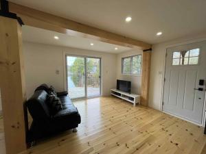 a living room with a black couch and a television at Chalet lac Chantelle in Chertsey