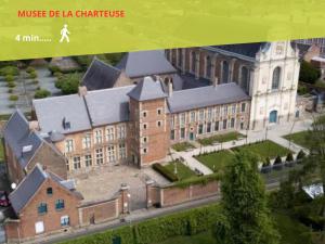 an image of a large brick building with a church at 2 chambres en RDC avec terrasse 4 personnes in Douai