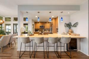 a kitchen and dining room with a large island with bar stools at Kapalua Ridge Villas 1723 · KRV 1723 Luxury Ocean View + Free Lu in Kahana