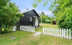 a small black house with a white picket fence at 2 Bedroom Awesome Home In Hasle in Hasle