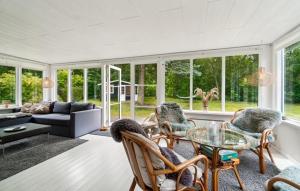 a living room with a glass table and chairs at 2 Bedroom Awesome Home In Hasle in Hasle