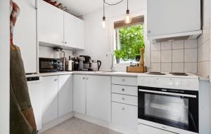 a white kitchen with white cabinets and a window at 2 Bedroom Awesome Home In Hasle in Hasle