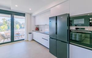 eine Küche mit einem grünen Kühlschrank und einem Tisch in der Unterkunft Lovely Apartment In Torremolinos in Torremolinos