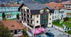 a large building with cars parked in a parking lot at El Ryo 2 in Călimăneşti