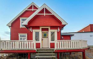 Lovely Home In Abelvær With Wifi في Abelvær: بيت احمر فيه شرفه بيضاء وباب