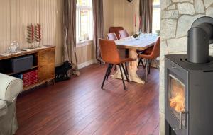Lovely Home In Abelvær With Wifi في Abelvær: غرفة معيشة مع طاولة ومدفأة