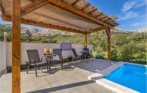 Draga BašćanskaにあるCozy Apartment In Baska With Swimming Poolのパティオ(テーブル、椅子付)、スイミングプールが備わります。