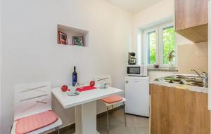 Draga BašćanskaにあるCozy Apartment In Baska With Swimming Poolの白いキッチン(テーブル、シンク付)