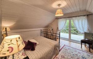 a bedroom with a bed and a large window at Beach Front Home In Vaksdal With House Sea View in Stavenesli