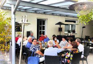a group of people sitting at a table in a patio at Hotel & Restaurant Alte Molkerei Kölleda in Kölleda