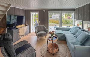 ein Wohnzimmer mit einem blauen Sofa und einem Fernseher in der Unterkunft 4 Bedroom Lovely Home In Færvik in Gjerstad