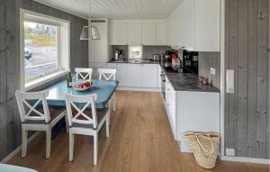 eine Küche mit weißen Schränken und einem Tisch und Stühlen in der Unterkunft 4 Bedroom Lovely Home In Færvik in Gjerstad