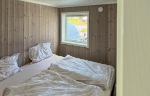 ein ungemachtes Bett in einem Zimmer mit Fenster in der Unterkunft 4 Bedroom Lovely Home In Færvik in Gjerstad