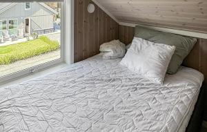 ein großes Bett in einem Zimmer mit Fenster in der Unterkunft 4 Bedroom Lovely Home In Færvik in Gjerstad + 12 Fotos