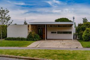 a house with a large driveway at Casa Angelica - Casa en Barrio Cerrado Arenas del Sur para 6 PAX con Pileta y Parilla in Mar del Plata
