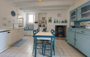 a kitchen with a blue table and chairs in it at Gorgeous Home In Dompierre-Sur-Charente in Dompierre-sur-Charente