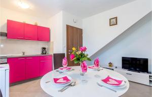 a kitchen with a white table and red cabinets at Cozy Apartment In Baska With Swimming Pool in Draga Bašćanska