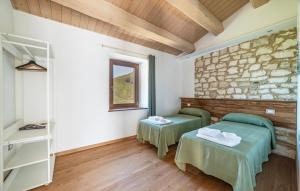 a room with two beds and a stone wall at Lovely Home In Castelletta in Precicchie +12 photos