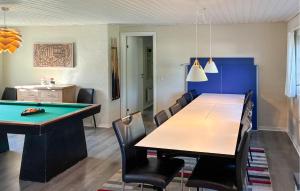 a dining room with a table and a pool table at Lovely Home In Væggerløse With Sauna in Marielyst