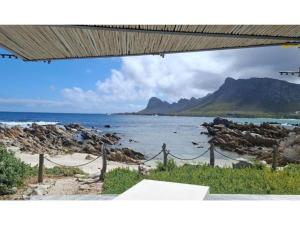 a view of a beach with a mountain in the background at Pringle Bay Villa in Pringle Bay