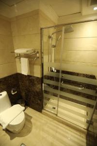 a bathroom with a toilet and a glass shower at Three Points Al Salama in Jeddah