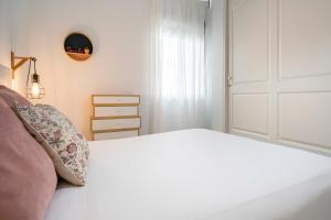 1 dormitorio con cama blanca y puerta blanca en Alohamundi Rocío, en Sevilla 17 fotos más