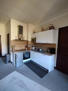 a kitchen with white cabinets and a counter top at Appartement T3 2 chambres - 6 personnes in Luz-Saint-Sauveur