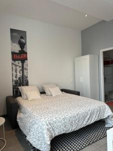 een slaapkamer met een bed met een dekbed erop bij Joli studio de 30 m2 in Laval