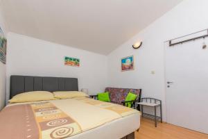 a bedroom with a bed and a chair at House Osti in Rogoznica