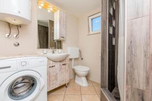 a bathroom with a washing machine and a toilet at House Osti in Rogoznica +22 photos