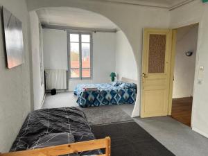 a room with two beds and an archway in it at Paradeux - Chambre dans grande Maison Gite sur Argenteuil, Parking dans cour securisée, pour ouvriers ou groupes de travailleurs in Argenteuil