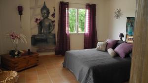 a bedroom with a bed and a picture of a statue at Villa couleurs du sud in Bize-Minervois