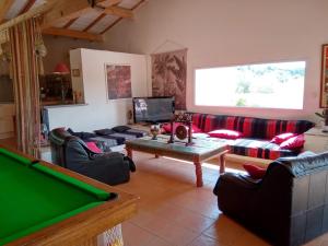 a living room with couches and a pool table at Villa couleurs du sud in Bize-Minervois