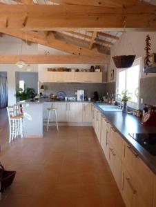 a large kitchen with white cabinets and a counter top at Villa couleurs du sud in Bize-Minervois
