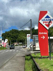 a red sign on the side of a road at Maison traditionnelle proche Malendure in Bouillante