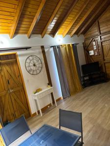 a room with a clock on the wall and a table at Maison traditionnelle proche Malendure in Bouillante