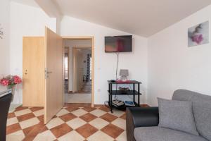 a living room with a couch and a television on the wall at Apartments Sanja in Vir