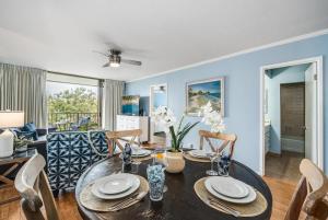 Un comedor y una sala de estar con mesa y sillas. en Kahana Manor 608 · KMN 608 Partial Ocean Views from 2BD Kahana C, en Kahana