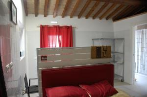 a bed in a room with a red curtain at Il Moraiolo - Casale Piccolo in Pigge
