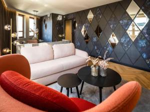 a living room with a couch and a table at Hotel Am Konzerthaus - MGallery Collection in Vienna