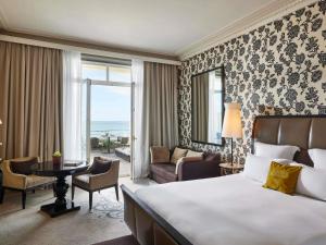 a bedroom with a large bed and a living room at Le Grand Hotel de Cabourg - MGallery Collection in Cabourg +220 photos