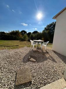 a table and two chairs on a gravel patio at Villa Belle Vue in Laroque