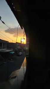 a sunset is seen through a window of a building at Loft Hipolito in Belém