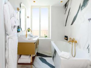 ein weißes Badezimmer mit Badewanne und Waschbecken in der Unterkunft Grand Hotel Beauvau Marseille Vieux-Port - MGallery Collection in Marseille + 83 Fotos