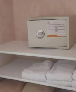 Ein weißer Karton steht neben Handtüchern auf einem Regal. in der Unterkunft Ad un passo dalle stelle 56 domina coral bay in Sharm El Sheikh