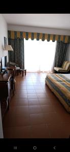 ein Schlafzimmer mit Bett, Schreibtisch und Fenster in der Unterkunft Ad un passo dalle stelle 56 domina coral bay in Sharm El Sheikh