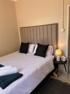 a large bed with white sheets and black pillows at S Residence in Kimberley +13 photos