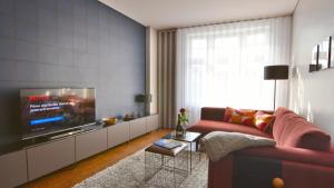 a living room with a red couch and a tv at Carl.22 City Appartements in Eisenach