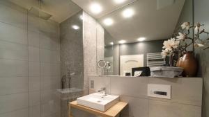 une salle de bain avec un lavabo et un miroir dans l'établissement Carl.22 City Appartements, à Eisenach
