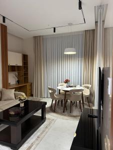 a living room with a table and a dining room at Luxury Apartment at Nest One Residence in Tashkent